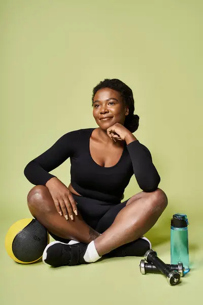 Young fit african american woman enjoys a moment of rest after intense exercise in a studio. — Stock Photo