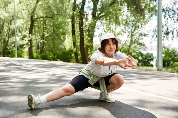 Una giovane donna si allunga all'aperto in un parco, mostrando il suo impegno per il fitness. — Foto stock