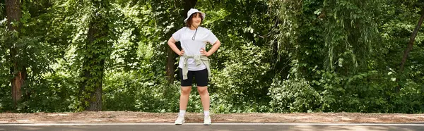 A fit young woman confidently walks a path, highlighting her dedication to fitness in nature, banner — Stock Photo