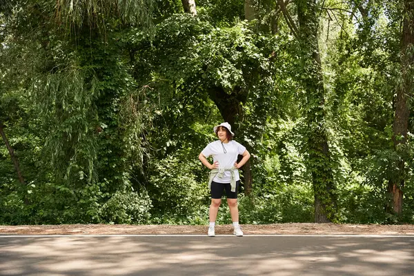 Una joven se ejercita con confianza en un parque vibrante, mostrando fitness y vitalidad. - foto de stock