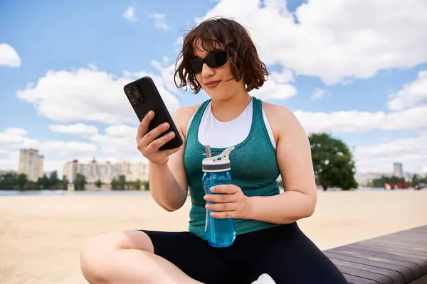 Young woman relaxes on a sunny day, sipping water and enjoying the outdoor summer atmosphere. — Stock Photo