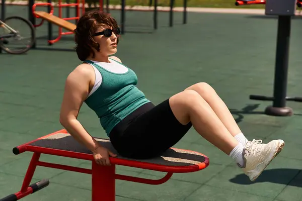 In forma la donna si allena all'aperto, concentrandosi sulla forza e il fitness in un ambiente vivace parco. — Foto stock