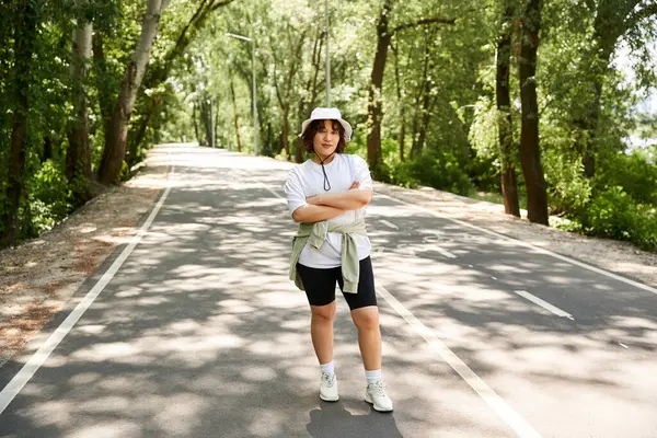 In the heart of summer, a young woman relishes her time outdoors on a serene pathway. — Stock Photo