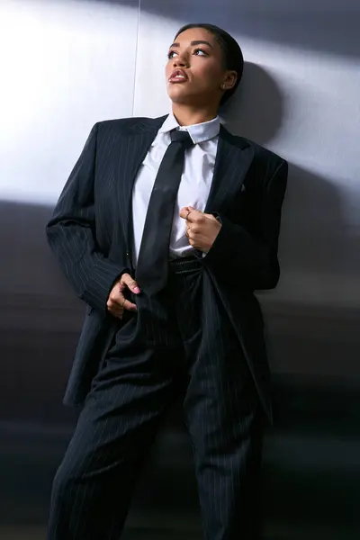 Mujer joven de moda muestra su estilo sofisticado en un traje elegante mientras posa. - foto de stock