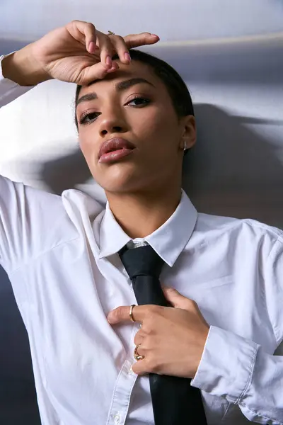 Elegante giovane donna posa con grazia in un ambiente urbano moderno in mostra il suo abbigliamento alla moda. — Foto stock