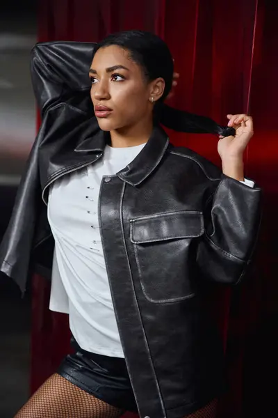 Eine schöne junge Frau posiert elegant in modischer Kleidung und strahlt Selbstbewusstsein und Stil aus. — Stockfoto
