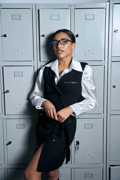 Eine stilvolle junge Frau posiert selbstbewusst in einem schicken Umkleidebereich und präsentiert ihr Outfit. — Stockfoto