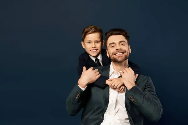 A father joyfully carries his son on his back, celebrating their special bond on Father Day. — Stock Photo