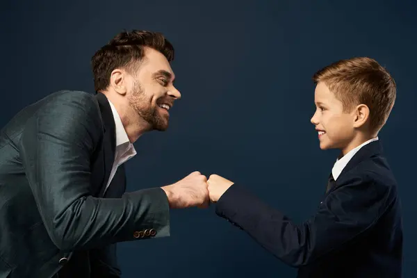 A father and son share a joyful fist bump, reflecting love and connection on Father Day 2025. — Stock Photo