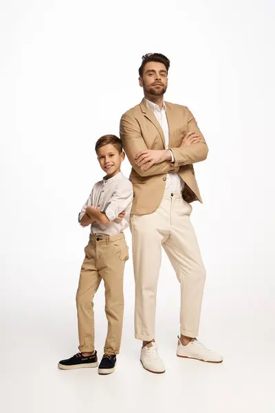 Father and son pose confidently, showcasing their stylish clothing and celebrating togetherness. — Stock Photo