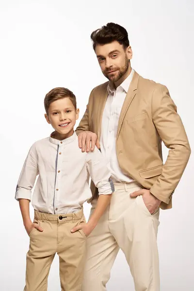 A father and son proudly pose together in stylish outfits, showcasing their bond on Fathers Day. — Stock Photo