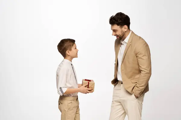 A joyful father and son share a meaningful moment while exchanging a special present for Father Day. — Stock Photo