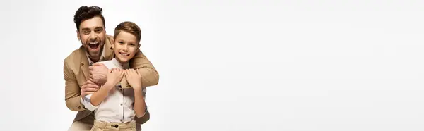 Doting father shares a heartwarming moment with his son, embracing each other in celebration. — Stock Photo