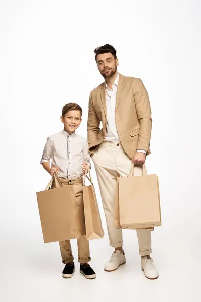 Vater und Sohn verbringen einen festlichen Moment mit Einkaufstüten, während sie gemeinsam den Vatertag genießen. — Stockfoto
