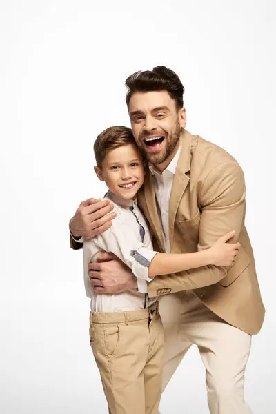 Vater und Sohn umarmen sich innig und strahlen während der Vatertagsfeier glücklich. — Stockfoto