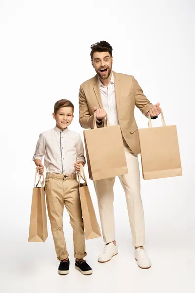 Excitement fills the air as a father and son proudly hold their shopping bags in celebration. — Stock Photo