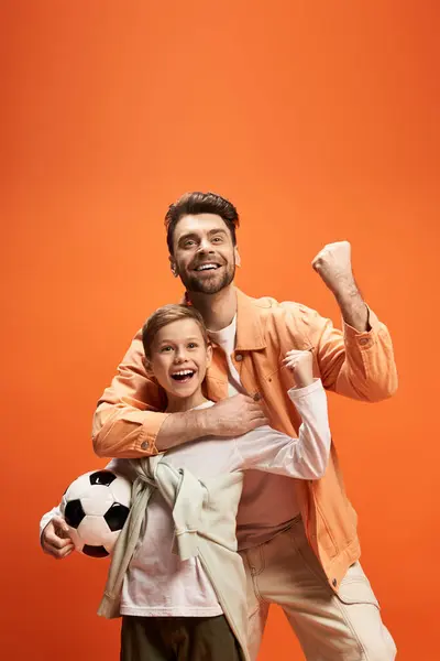 Un père et un enfant célèbrent la fête des pères avec rire et excitation en jouant au football. — Photo de stock
