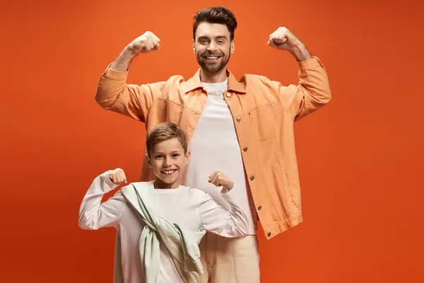 A father and son share smiles and flex muscles at a festive celebration. — Stock Photo