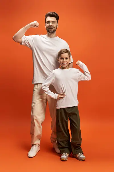 Father and son strike playful poses, showcasing their bond and strength in a vibrant setting. — Stock Photo