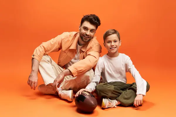 A father and son bond over their love for football in a joyful setting. — Stock Photo