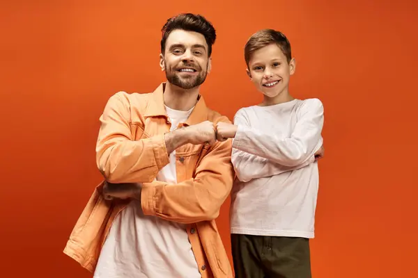 A joyful father and son share a fist bump, showcasing their strong bond in a festive setting. — Stock Photo