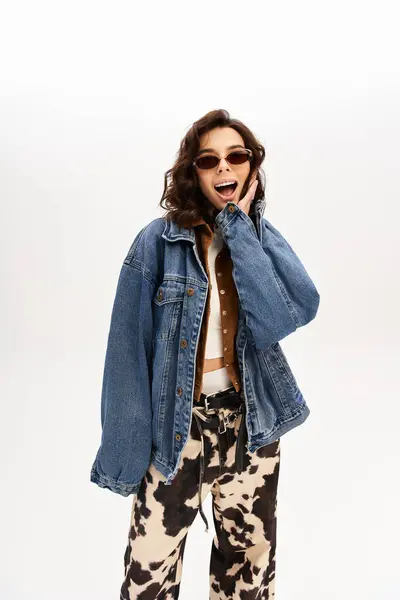 Young woman captures attention in trendy outfit with cow print pants in fashionable studio. — Stock Photo