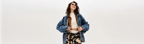 A young woman in a trendy outfit poses confidently against a grey backdrop, banner — Stock Photo