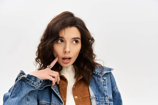 A chic young woman poses against a grey backdrop, exuding fashion flair. — Stock Photo