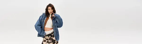 A young woman confidently poses with cow print pants against a neutral grey background, banner — Stock Photo