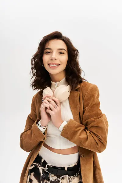 A young woman exudes confidence in cow print pants and a stylish outfit in a studio. — Stock Photo