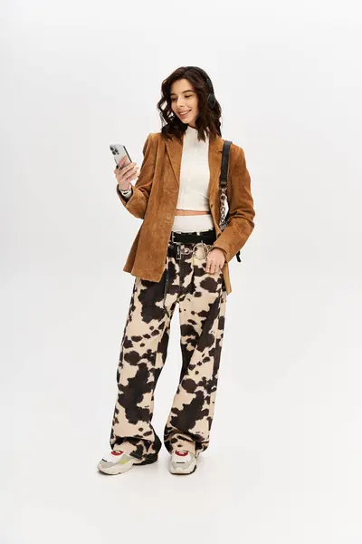 Young woman dressed in chic outfit captures attention with her cow print pants and confident pose. — Stock Photo