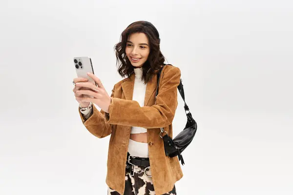 Young stylish woman enjoys taking selfies in her trendy cow print pants and brown jacket. — Stock Photo