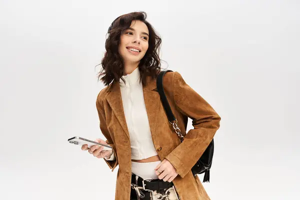 Trendy young woman poses confidently in cow print pants, stylishly accessorized in a studio. — Stock Photo