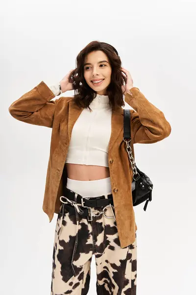A fashionable young woman poses confidently in trendy cow print pants and a stylish blazer. — Stock Photo