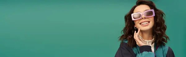 A stylish young woman confidently shows off her sporty look against a turquoise backdrop, banner — Stock Photo