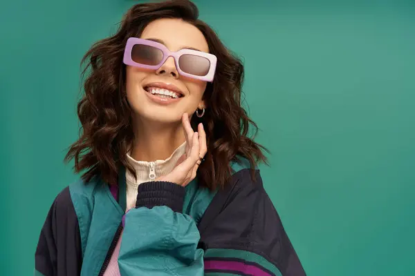 Charming young woman in stylish sportswear poses confidently in a bright studio, exuding joy. — Stock Photo