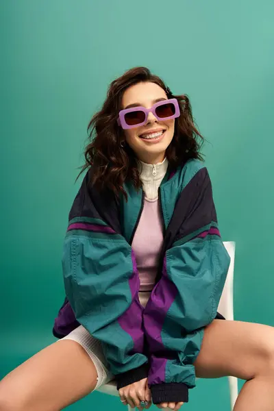 A young stylish woman with sunglasses showcases sporty fashion in a vibrant studio setting. — Stock Photo