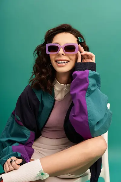 A fashionable young woman showcases her trendy sporty outfit while sitting casually. — Stock Photo