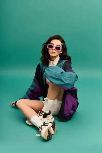 A young woman showcases her trendy sporty outfit in a vibrant studio setting. — Stock Photo
