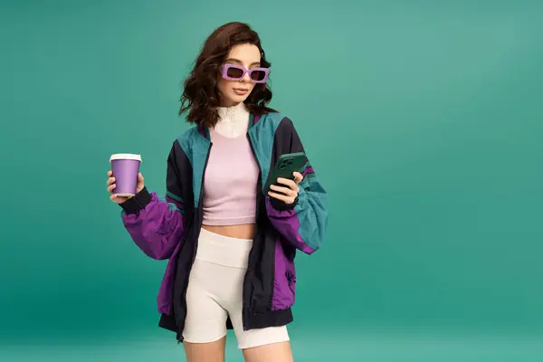 A fashionable young woman showcases her sporty outfit while holding a cup, exuding confidence. — Stock Photo