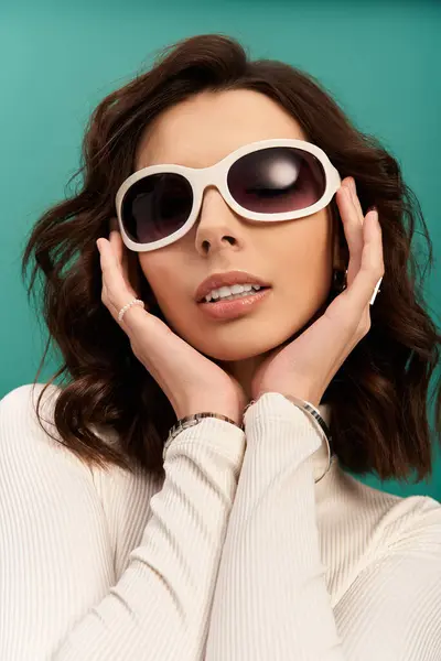 Stylish woman showcases trendy sporty fashion with accessories on a bright studio backdrop. — Stock Photo