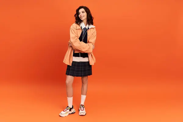 With arms crossed, a young woman showcases a chic skirt and jacket, radiating confidence in style. — Stock Photo