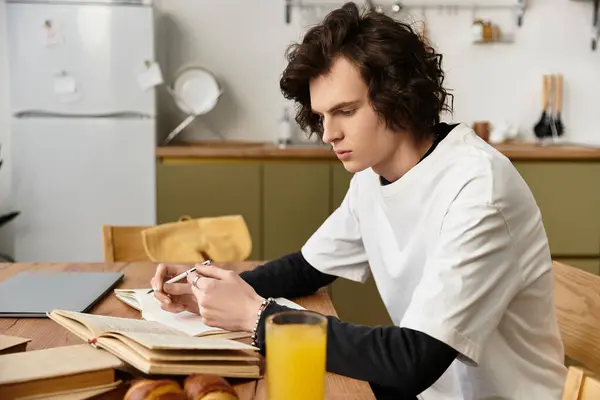 Cozy setting shows a young man focused on reading while enjoying breakfast at home. — Stockfoto