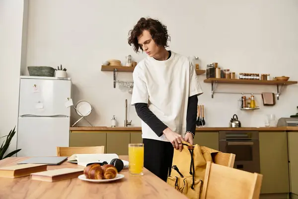 A young man enjoying a calm morning in a cozy kitchen, packing his bag with essentials. — Fotografia de Stock