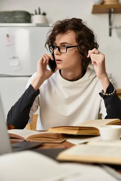 Cozy afternoon at home as a young man talks on the phone, surrounded by books and warmth. — Photo de stock