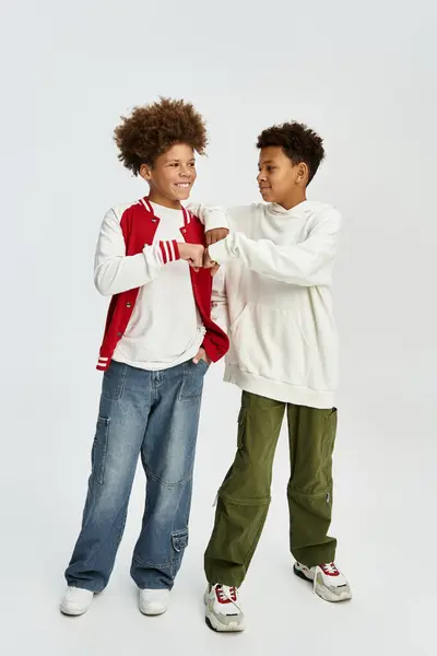 Two adorable young boys share a moment of camaraderie while dressed in trendy clothing. — Stock Photo