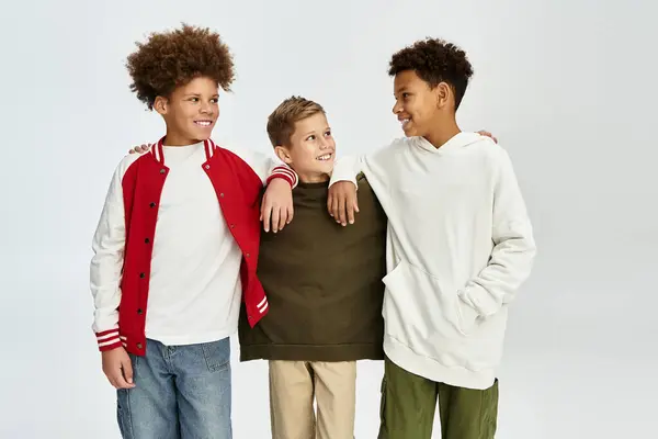 Three adorable boys share smiles and laughter while showcasing their trendy attire together. — Stock Photo
