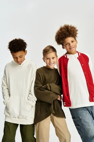 Tres niños pequeños muestran sus trajes elegantes mientras celebran su amistad y alegría. - foto de stock