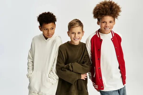 Tres chicos adorables en trajes elegantes y coloridos muestran su vínculo y felicidad juntos. — Stock Photo