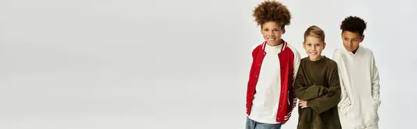 Three adorable boys share a joyful moment together, proudly displaying their fashionable attire. — Stock Photo